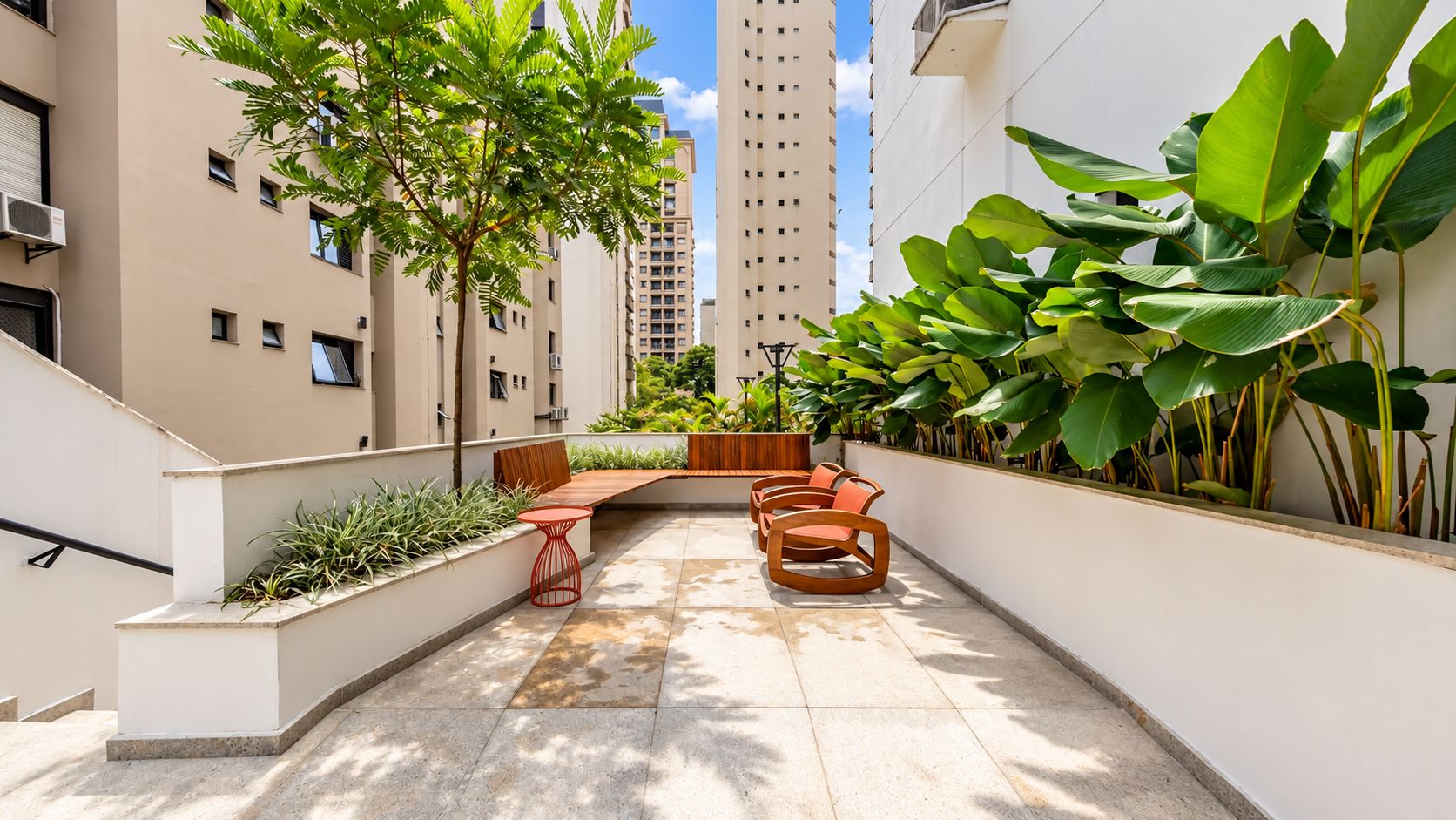 A courtyard with a seating area, plants, and a staircase.