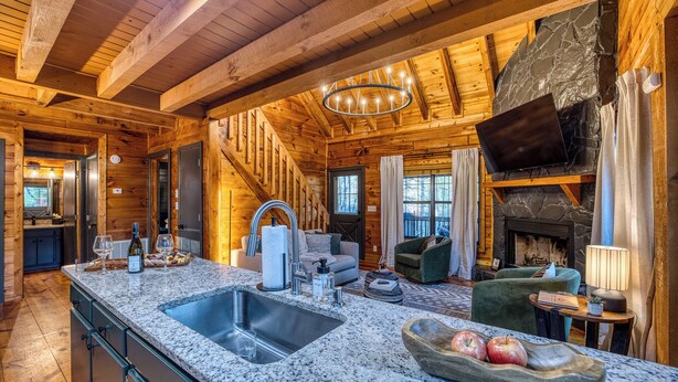 A log cabin interior with a kitchen, dining area, and living room. - Moon Lake Retreat - Kayaks, Fishing, Private shoreline, Hot tub, Room to Roam (Blue Ridge)