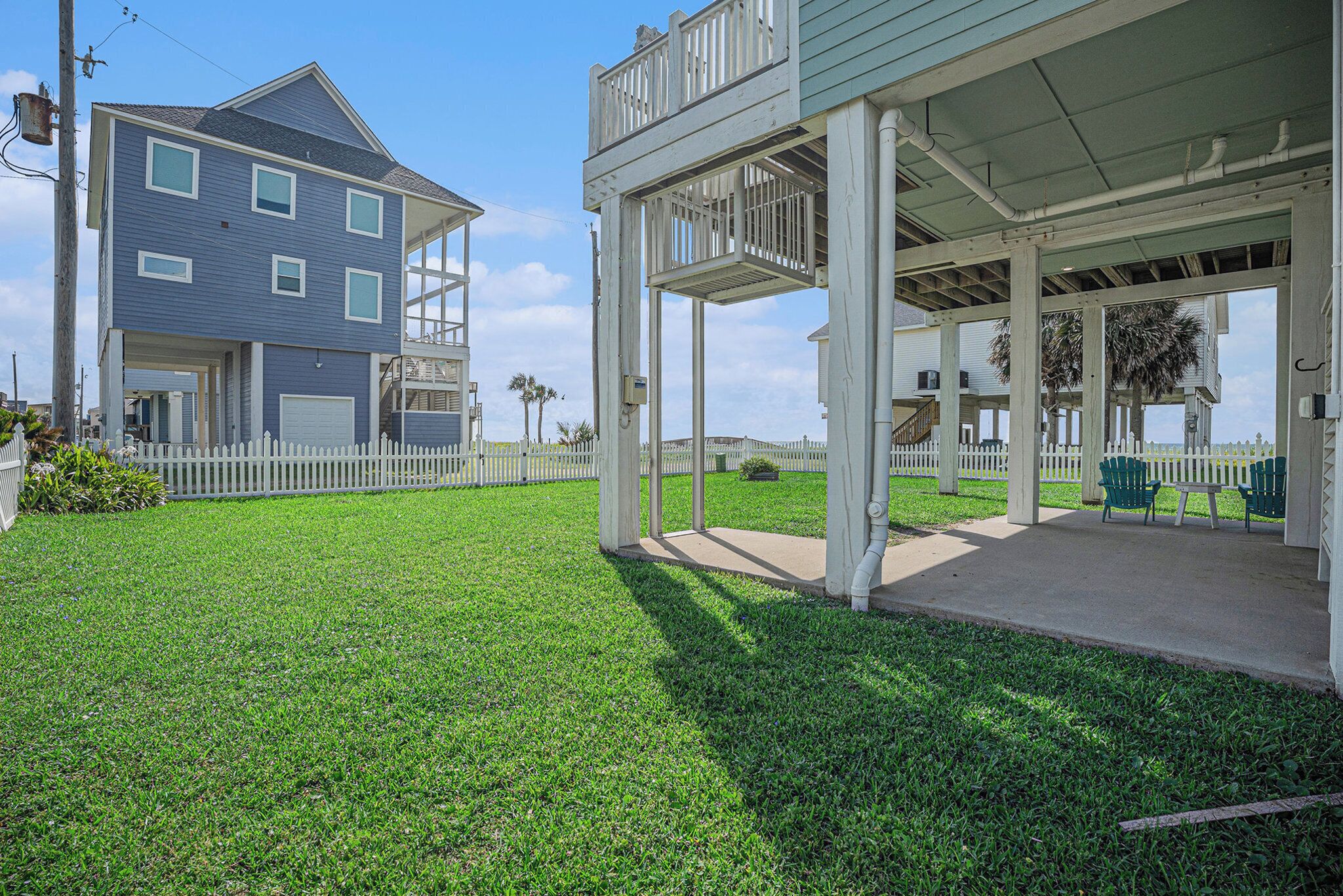 A two-story house with a covered porch and a fenced yard.