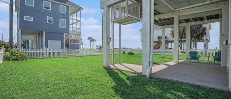 A two-story house with a covered porch and a fenced yard.