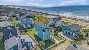 A coastal residential area with houses, a beach, and the ocean. - Beachside Vibes (Galveston)