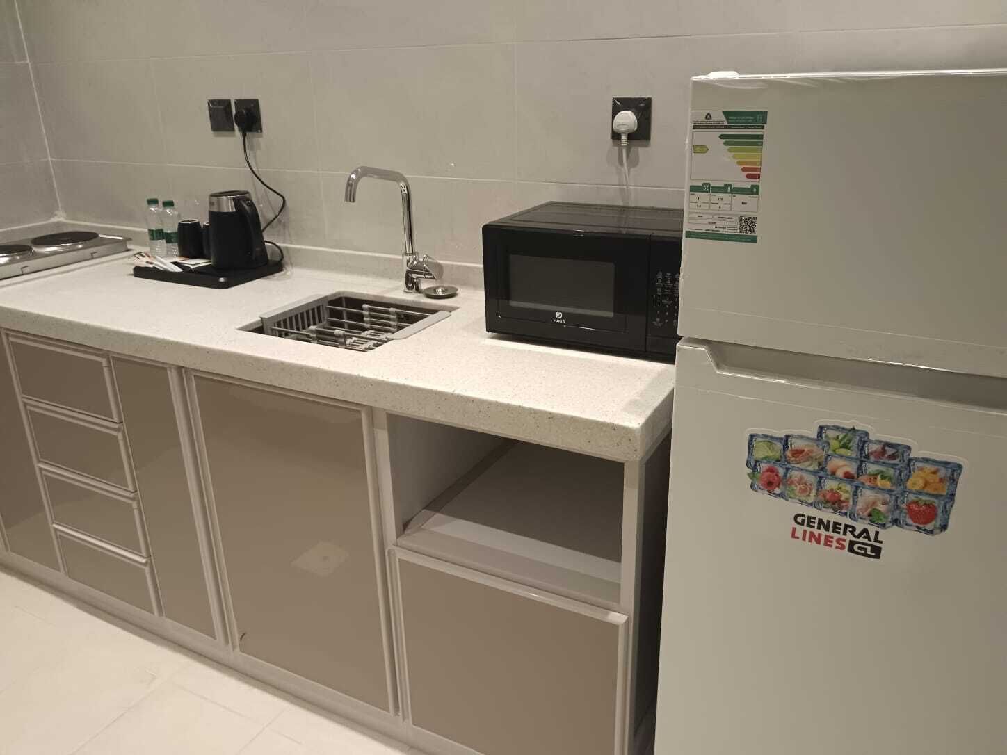 A kitchenette with a sink, a microwave, a refrigerator, and a coffee maker.