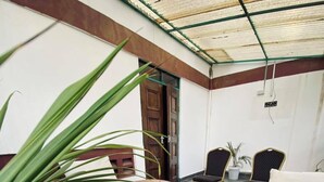 Una habitación con dos sofás marrones, una mesa de madera y una planta en maceta.