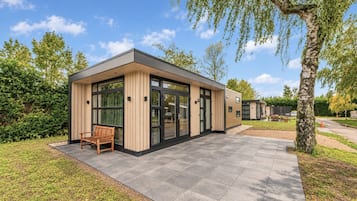 Un bâtiment moderne doté de grandes fenêtres et d’un banc à l’extérieur.