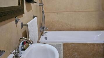 A bathroom with a sink, mirror, shower, and bathtub.