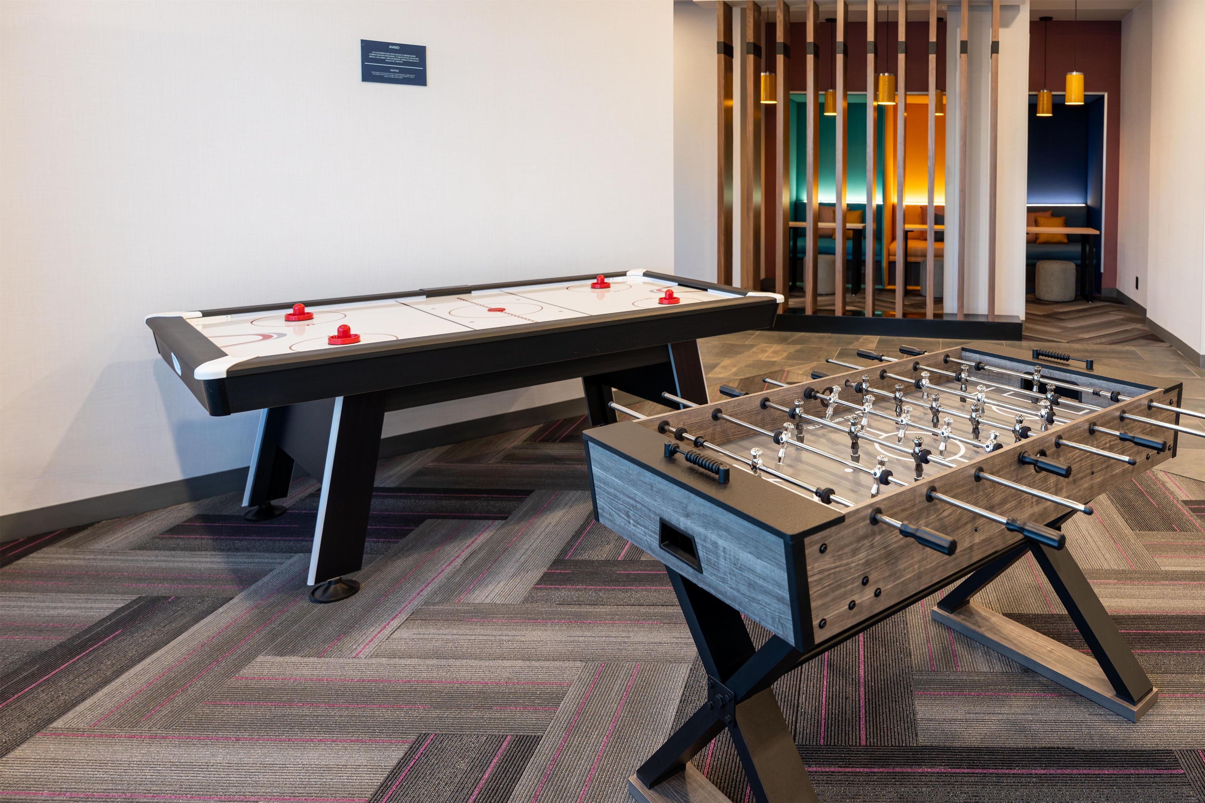 A foosball table and a table tennis table in a hotel room.