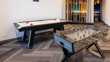 A foosball table and a table tennis table in a hotel room.