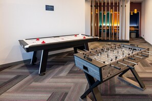 Een tafelvoetbal tafel en een tafeltennistafel in een hotelkamer.