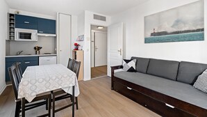 A compact living space with a kitchenette, dining area, and a sofa. - Air-conditioned flat with a balcony & swimming pool (Grasse)