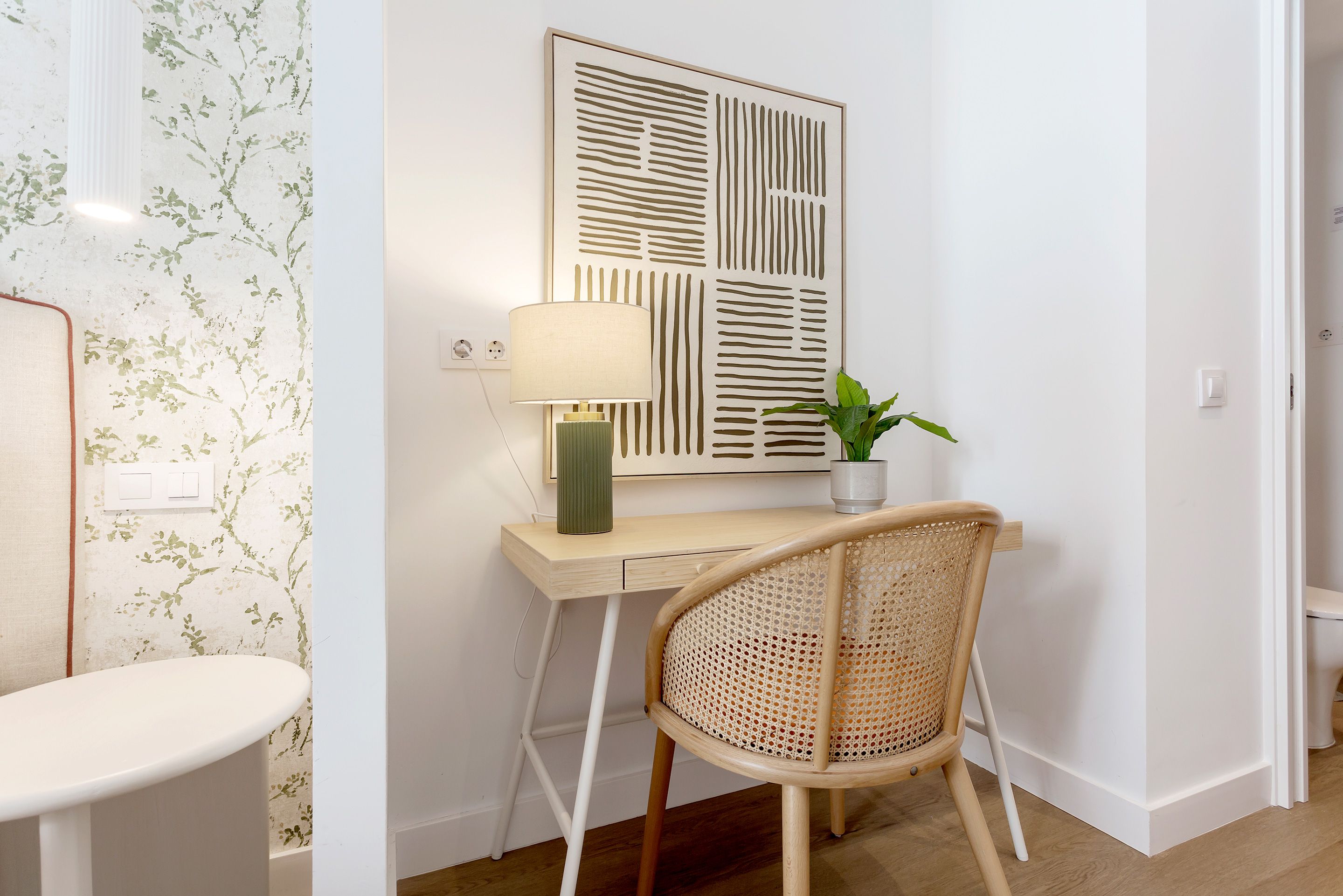 Une pièce comprenant un bureau, une chaise, une lampe et une plante en pot.