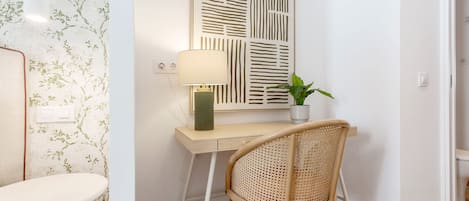 Une pièce comprenant un bureau, une chaise, une lampe et une plante en pot.