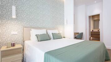 Een moderne slaapkamer met een groot bed, een nachtkastje, een stoel en een bureau.