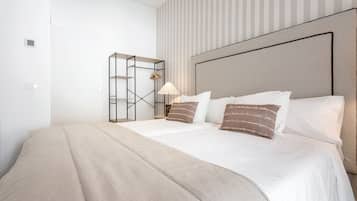 Una habitación de hotel con cama, mesita de noche, lámpara y armario.