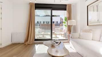 Una sala moderna con sofá, una mesa de centro y vistas al balcón exterior.