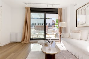 A modern living room with a sofa, a coffee table, and a view of a balcony. - Genteel Home Zabaleta (Madrid)