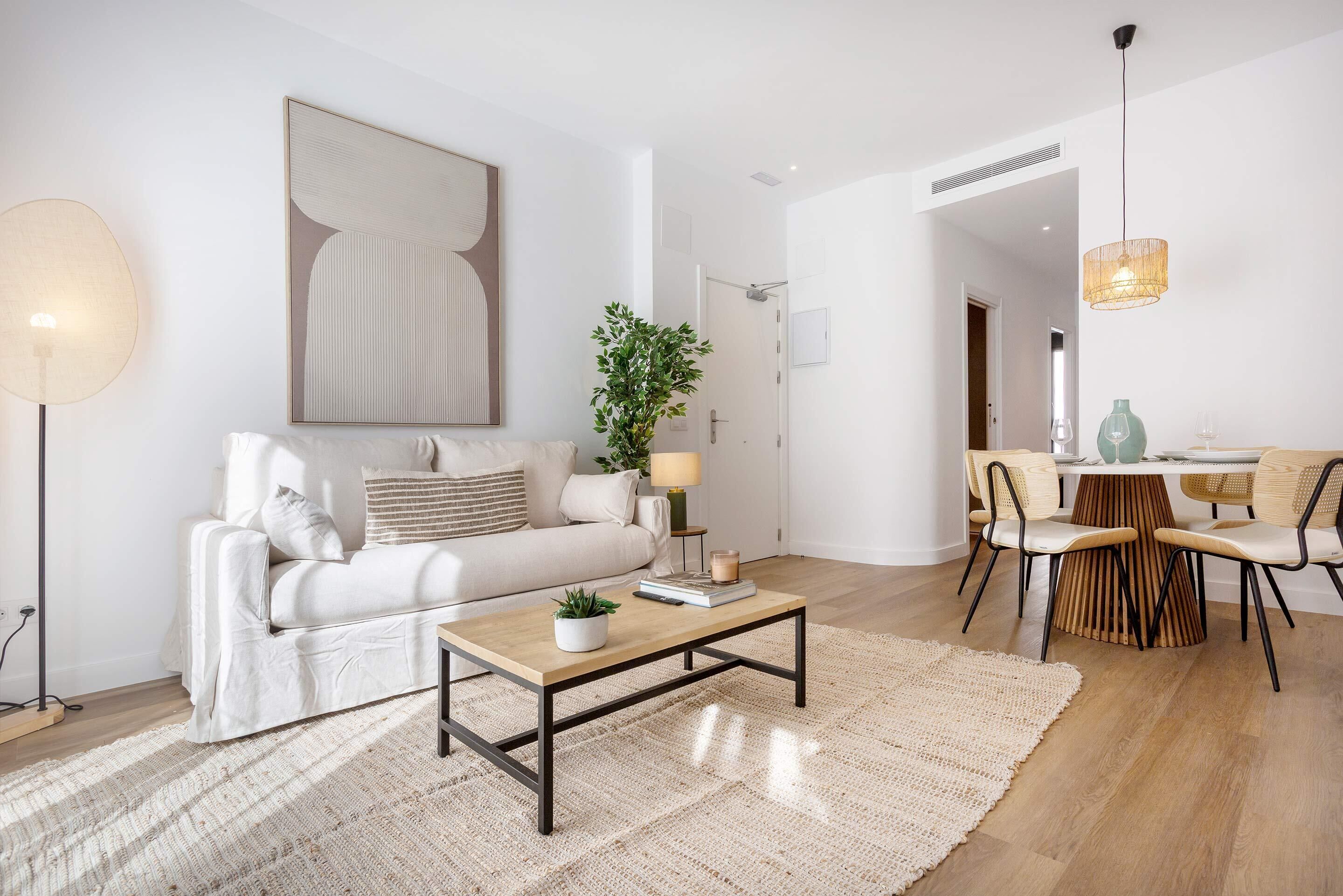 En moderne stue med sofa, sofabord og spiseplads.