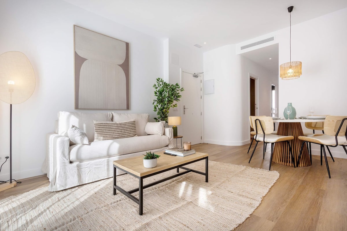 En moderne stue med sofa, sofabord og spiseplads.