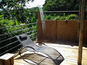 A wooden deck with a metal chair and a small table. - Charming accommodation in Gosier, 5 minutes from the beaches (Le Gosier)