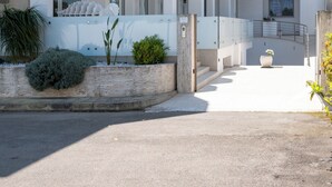 A modern multi-story building with balconies, a gated entrance, and a clear sky. - Hotiday Porto Cesareo Laguna (Porto Cesareo)