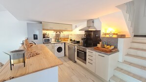 Une cuisine moderne équipée d’un lave-linge, d’un four à micro-ondes et d’une cuisinière.