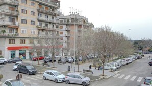 A multi-story residential building with balconies, a parking lot with cars, and a pedestrian crossing. - SAN GIOVANNI Appia Park - Stylish apartment with balcony - Metro A - 10 min City Center (Rome)