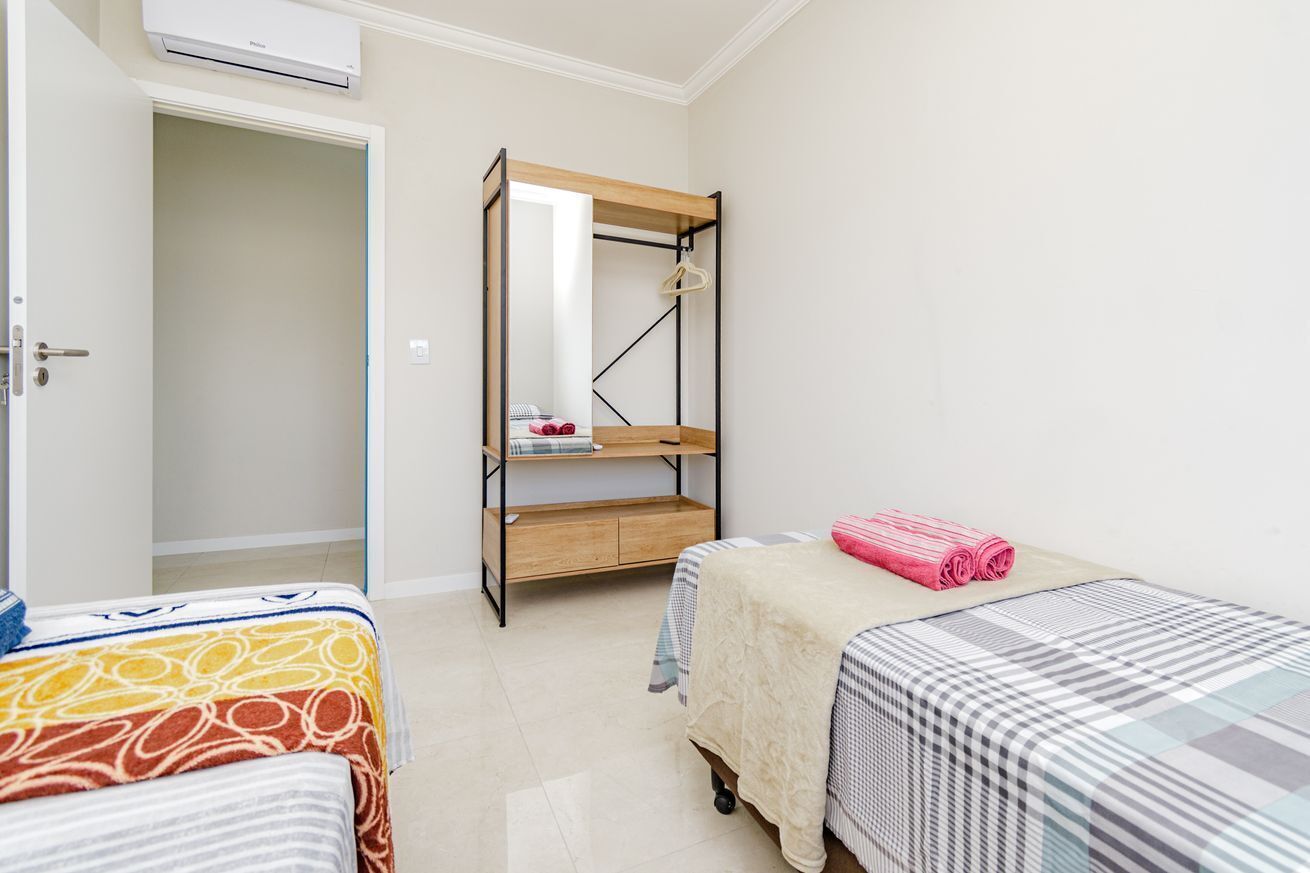 A bedroom with bunk beds, a wardrobe, and a mirror.