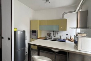 Une cuisine moderne équipée d’un réfrigérateur, d’un four, d’un évier et d’un four à micro-ondes.