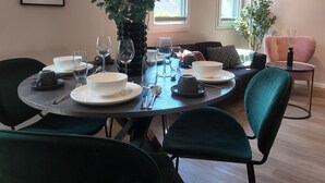 A dining area with a round table, chairs, and a vase of flowers. - Modern apartment for 2-4 guests with balcony (Bruttig-Fankel)