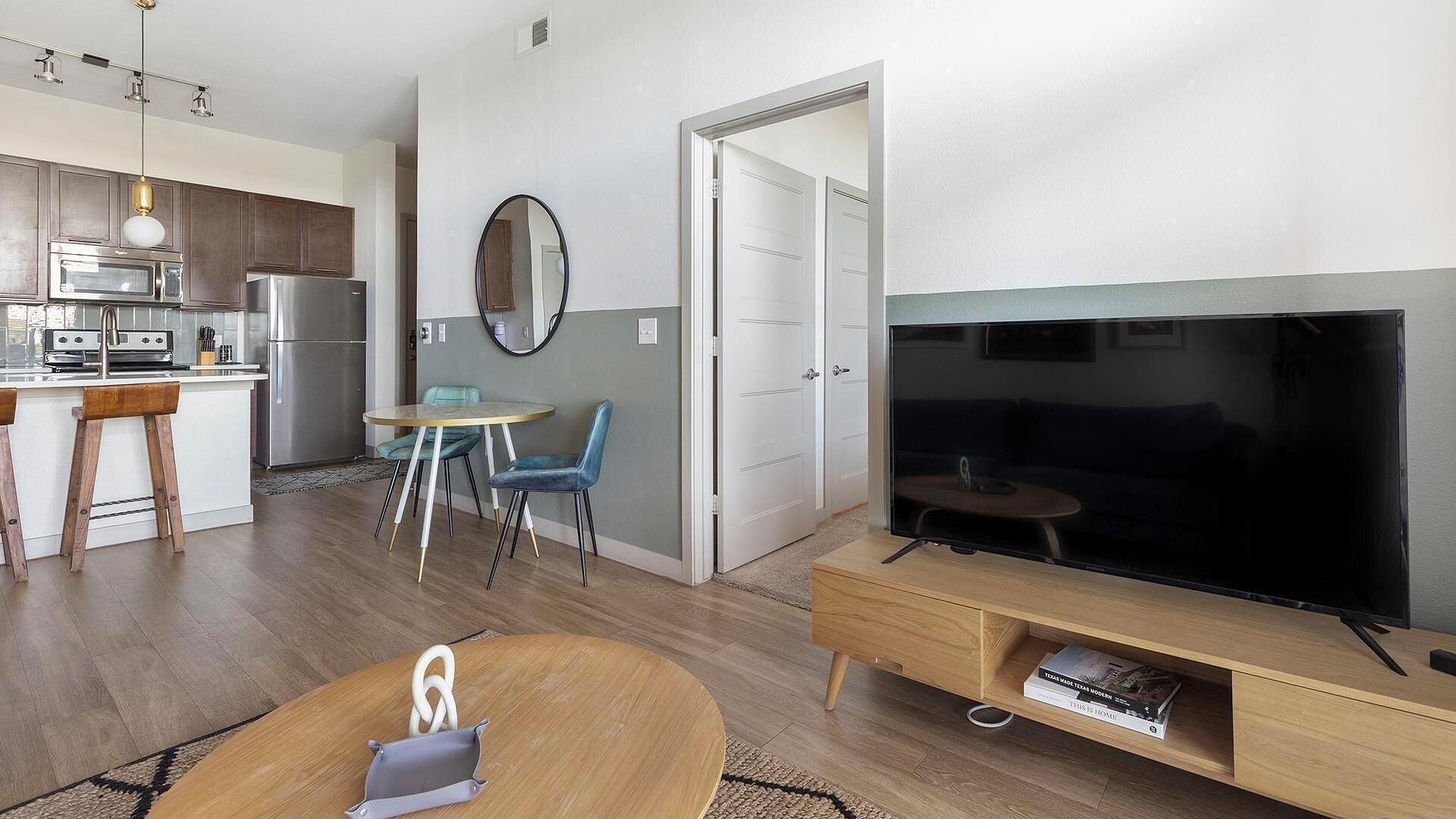 A modern apartment with a kitchen, dining area, and living room.