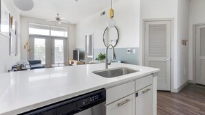 Eine moderne Küche mit Geschirrspüler, Spüle und Deckenventilator.