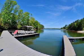 A calm river with a dock, a boat, and a canopy. - Greystone (Anderson)
