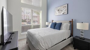 A neatly arranged bedroom with a bed, bedside tables, a lamp, and a wall-mounted artwork. - Landing Apartments Fort Worth Near Historic Southside (Fort Worth)