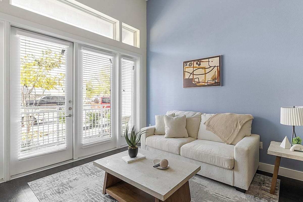 A living room with a sofa, a coffee table, a lamp, and a painting on the wall.