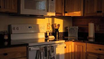 A kitchen with wooden cabinets, a microwave, a stove, and a sink.