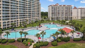 A hotel with multiple high-rise buildings, a central swimming pool, and surrounding greenery. - Luxe Dye Estates Townhome @ Barefoot - Golf, Pool, Hot Tub (North Myrtle Beach)