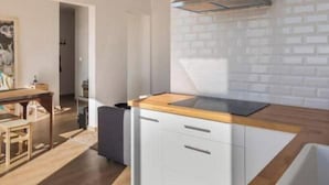 Een moderne keuken met een houten aanrechtblad, witte kastjes en een roestvrijstalen afzuigkap.