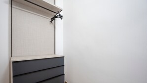 Una parete con una porta scorrevole e un mobile contenitore integrato con diversi cassetti.
