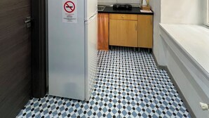 A compact kitchen with a refrigerator, microwave, and cabinets. - Cozy Loft Retreat by Chain Bridge – Stunning Danube & Parliament Views (Budapest)
