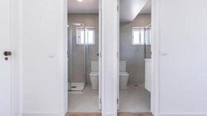 Un bagno con doccia, WC e finestra.