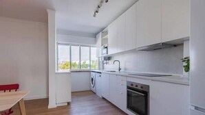 Una cucina moderna con mobili bianchi, una lavatrice e un forno.