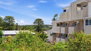 A modern building with a unique architectural design, featuring multiple balconies and large windows. - Yonder #5 - Walk to beach (Avoca Beach)