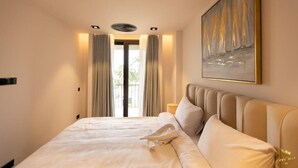 Habitación de hotel con cama, un cuadro y vista por una puerta.