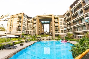 Ein modernes Hotel mit Pool, Außenbereich und einem zentralen Eingang.