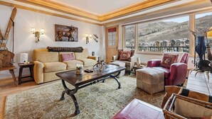 A cozy living room with a large window, a sofa, a coffee table, and a fireplace. - Lodge Tower 578 2BR at the base of Vail Mountain (Vail)
