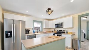 A modern kitchen with stainless steel appliances, a central island, and white cabinetry. - Steps to Ariel Park / Renovated 2BR Retreat (Mount Vernon)