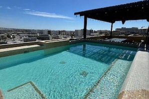 Ein klares Schwimmbecken mit Blick auf die Skyline im Hintergrund.