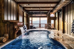 An indoor swimming pool with wooden walls and a view of the mountains. - Pool/HotTub/GameRoom/Theater/FirePit/VIEWS - Coal Camp Lodge (Sevierville)