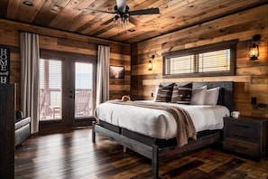 A wooden cabin-style bedroom with a bed, nightstands, and a ceiling fan. - Pool/HotTub/GameRoom/Theater/FirePit/VIEWS - Coal Camp Lodge (Sevierville)