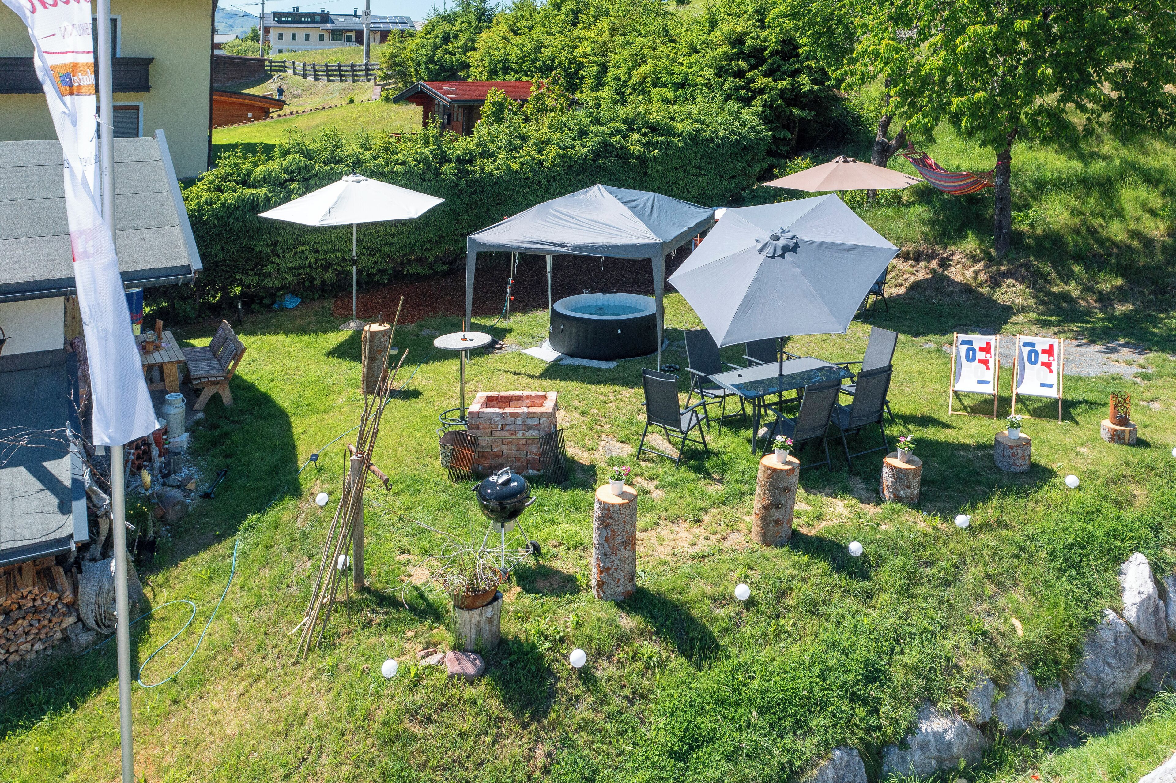 An outdoor patio with a tent, chairs, and a barbecue grill.