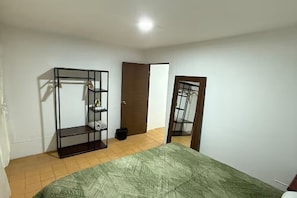 Ein Schlafzimmer mit einem Bett, einem Kleiderschrank und einer Tür.